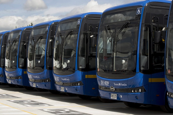 A row of blue buses parked next to each other